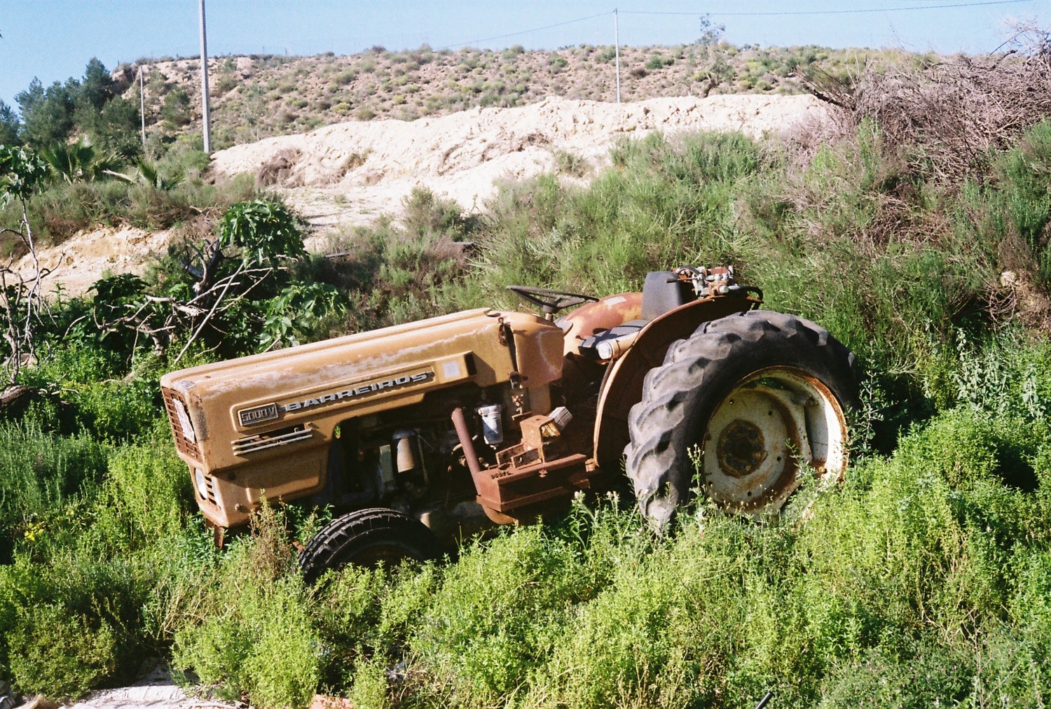 Nature reclaims an old tractor shot on Kodak ColorPlus 200 with a Olympus 35LC, by Tipsy