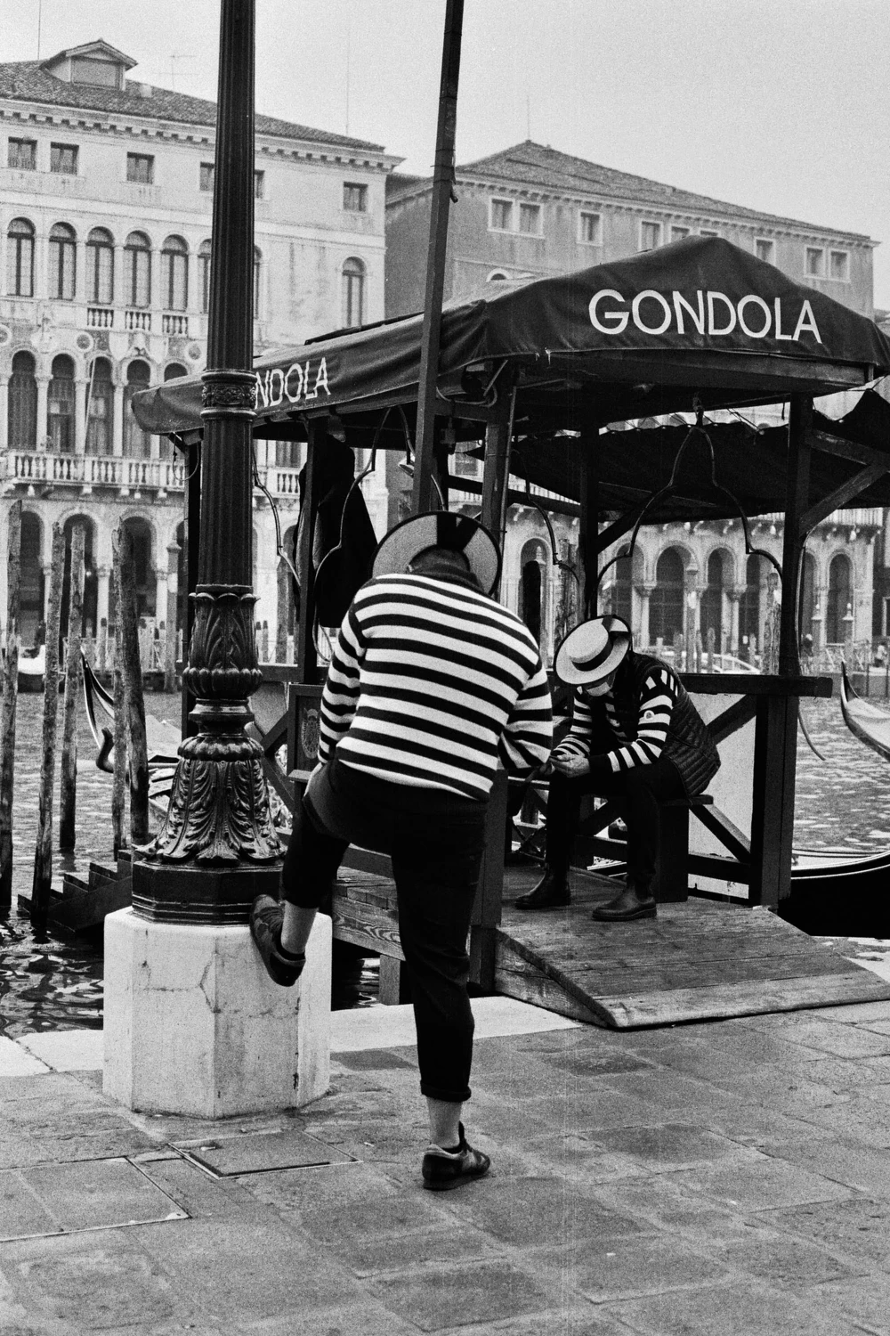 Gondoliers await tourists. shot on Ilford HP5 Plus 400 with a Canon T50, by Rebecca Abinti